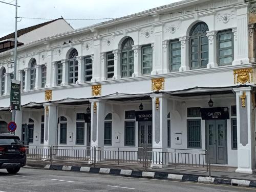 een wit gebouw op de hoek van een straat bij Loke Thye Kee Heritage Hotel in George Town