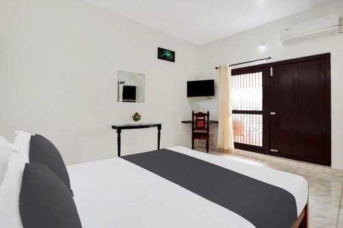 a bedroom with a large bed and a television at Ocean Queen Palace Kovalam in Trivandrum