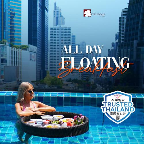 a woman in a pool with a tray of food at Hotel Clover Asoke - SHA Extra Plus in Bangkok
