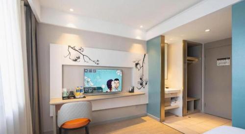 a living room with a television and a chair at Magnotel Harbin Medical University First Affiliated Hospital in Harbin