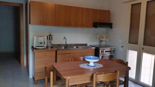 a kitchen with a wooden table and a kitchen with a sink at San Pietro Apartments in San Pietro in Bevagna