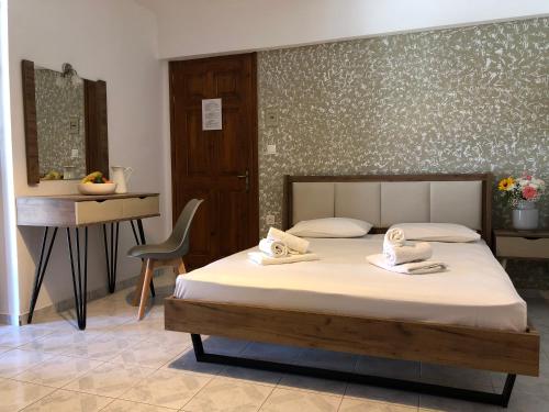 a bedroom with a bed and a desk and a chair at Armonia Guest House in Skiathos