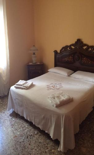 a bedroom with a large white bed with two towels on it at Affittacamere di Fabio Principale in Talsano