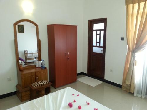 a room with a mirror and a dresser and a door at Villa River View in Aluthgama