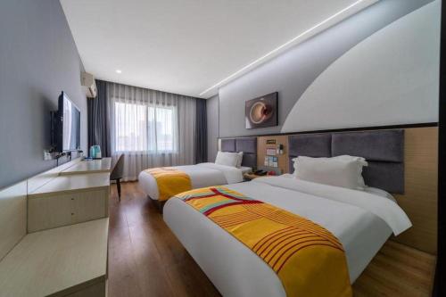um quarto de hotel com duas camas e uma televisão em Pai Hotel Xi'an Electronic Zheng Street em Xian