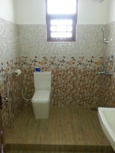 a bathroom with a toilet and a sink and a window at Villa River View in Aluthgama