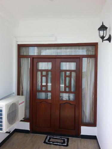 a wooden door in a room with a fan at Villa River View in Aluthgama