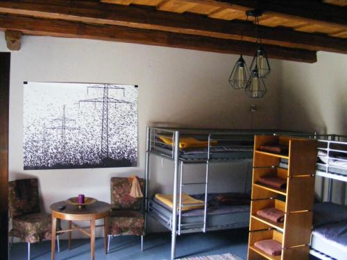 a room with bunk beds and a table and chairs at Bakancstanya in Kétbodony
