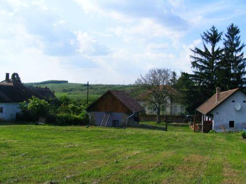 a group of houses in a grassy field at Bakancstanya in Kétbodony
