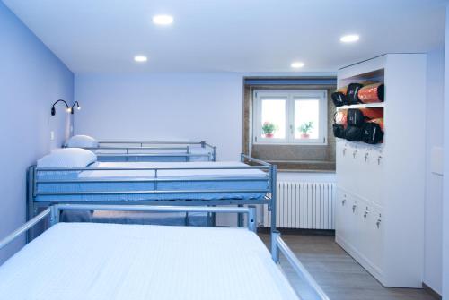 a hospital room with two beds and a window at Albergue Linares in Santiago de Compostela