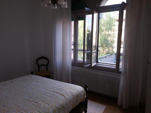 a bedroom with a bed and a large window at B&B Casa Carbonara in Cividale del Friuli