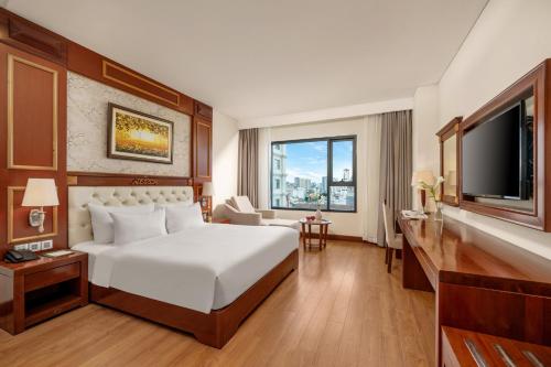 岘港DLG岘港酒店的一间带床和大窗户的酒店房间