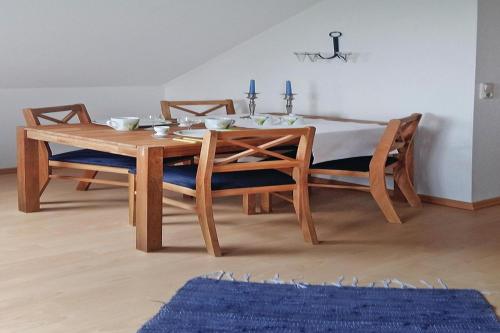 een houten tafel met 2 stoelen en een eetkamer bij Apartments, Toenning in Tönning