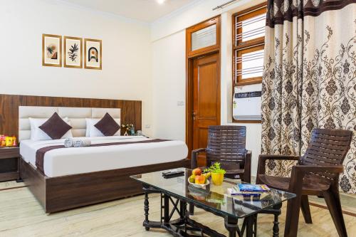 een hotelkamer met een bed, een tafel en stoelen bij Hotel Warm Welcome Inn 51 in Noida