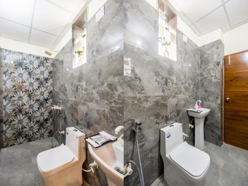een badkamer met twee toiletten en een wastafel bij Hotel Warm Welcome Inn 51 in Noida