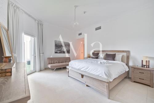 um quarto branco com uma cama e uma cadeira em Two - Bedroom Crown Jewel on Yas island by Ayla em Yas Island