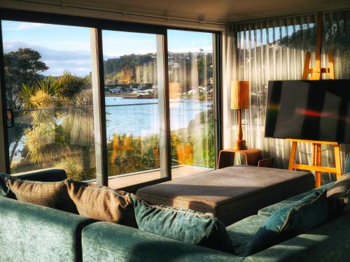 a living room with a couch and a large window at Wellington Seaside Haven in Wellington