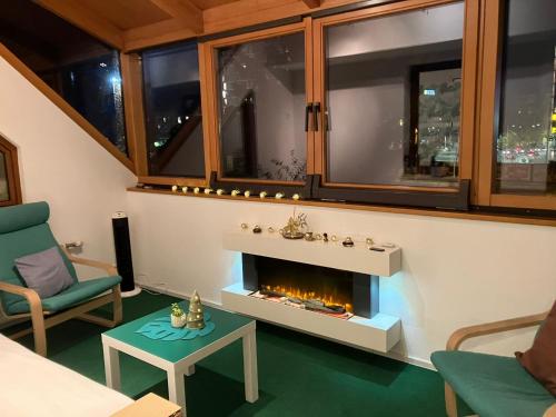 a living room with a fireplace and a green chair at Arena Apartments in Graz