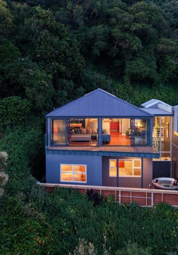 a blue house with a roof on a hill at Wellington Seaside Haven in Wellington