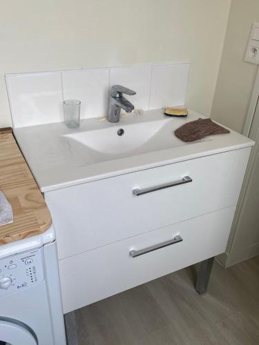 a white sink in a kitchen next to a stove at Le Fil du Temps in Le Bény-Bocage