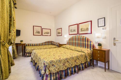 a hotel room with two beds and a tv at Hotel Italia in Siena