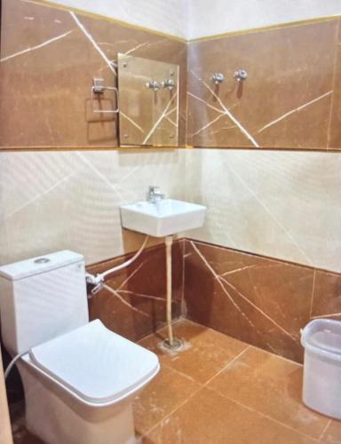a bathroom with a toilet and a sink at Shree Radha inn in Ayodhya