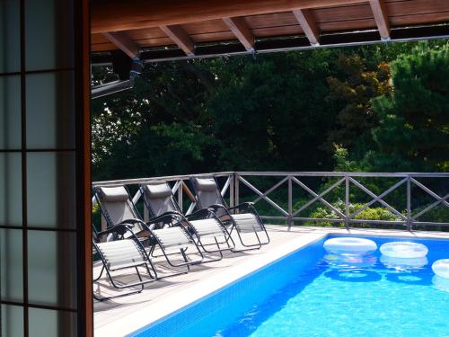 a patio with chairs and a swimming pool at パーパスリゾート EG Sky terrace 熱川 in Higashiizu
