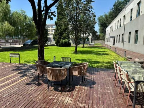 北京秋果s酒店的建筑物旁边的砖砌露台上摆放着一张桌子和几把椅子。