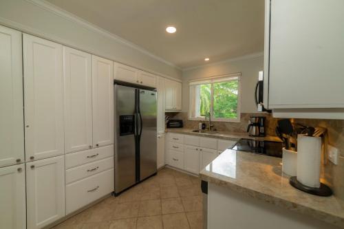 a kitchen with white cabinets and a stainless steel refrigerator at Veranda 4B - 3bdr 3bath in Isla Herradura
