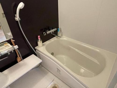 a bath tub in a bathroom with a shower at 京樽3号 1棟貸切 一軒家 3-Bedrooms Duplex Private Villa KYOTARU3 in Otaru