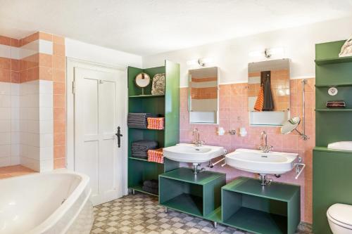 ein Badezimmer mit zwei Waschbecken und einer Badewanne in der Unterkunft Augenweide in Bad Feilnbach