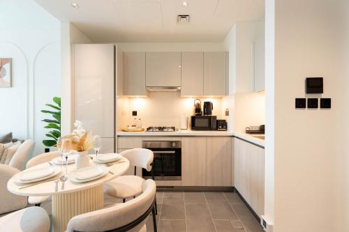 a kitchen and living room with a table and chairs at Luxury 1BR Apartment - Pool View - The Crest Dubai in Dubai