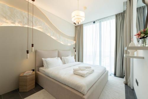 a bedroom with a large white bed with white pillows at Luxury 1BR Apartment - Pool View - The Crest Dubai in Dubai