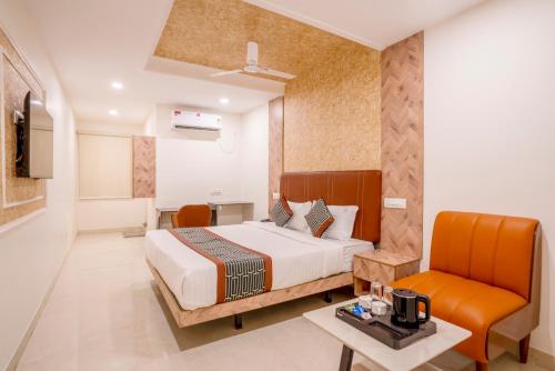 a hotel room with a bed and a chair at Hotel Helixo Classic Kompally in Hyderabad