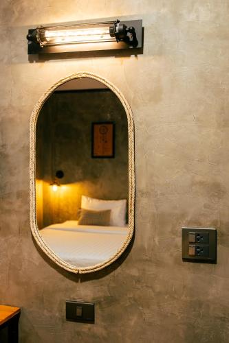 a mirror on a wall with a bed in it at Lanta Chaolay in Ko Lanta