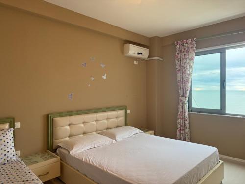 都拉斯Panoramic Sea View Stay Beachfront Center Location的一间卧室，里面有一张床和一扇窗户。