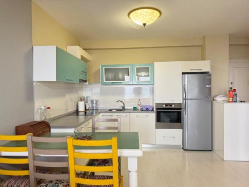 都拉斯Panoramic Sea View Stay Beachfront Center Location的配有桌椅和冰箱的厨房