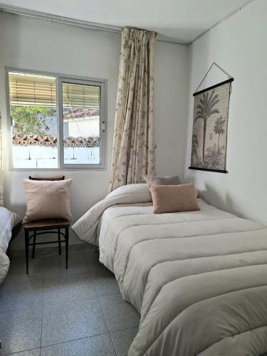 a bedroom with two beds and a window at Casa de la abuelita in Cazorla