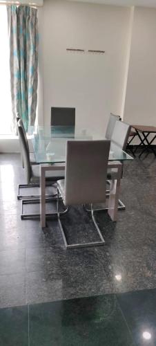 een glazen tafel met stoelen en een laptop erop bij 7Hills Residency in Anantapur