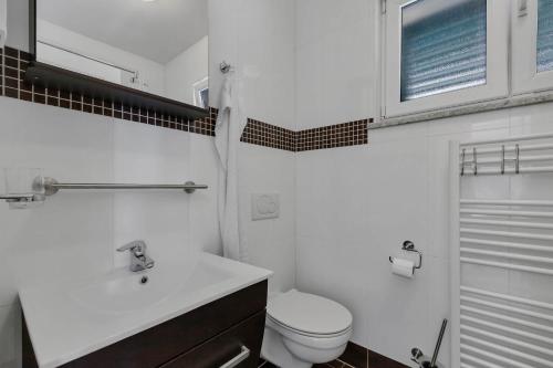 Holiday Home Berulia في بريلا: حمام أبيض مع مرحاض ومغسلة