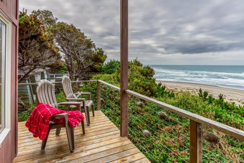 a porch with two chairs and the beach at RidgeTop in Lincoln City