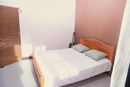 a small bedroom with a bed with white sheets at Firenze in Hikkaduwa