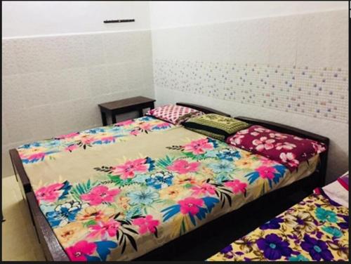 a bedroom with a bed with a flower pattern on it at JS Homestay in Nāgercoil