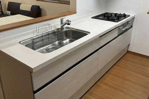 a kitchen with a sink and a stove at Riverside Mizukiリバーサイドミズキ in Uruma