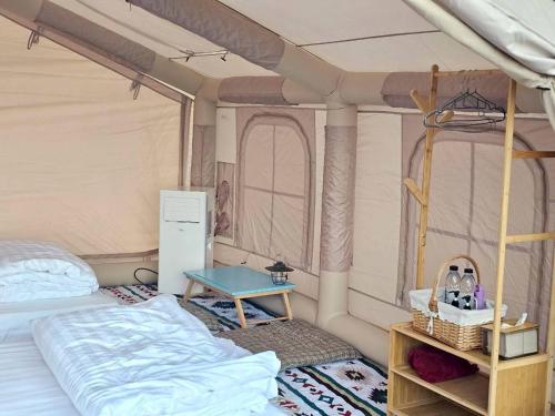 Ban Muang Thaeoภูผาหน้าเล PhuPha-NaLay Cafe'n Camping的带床和桌子的卧室