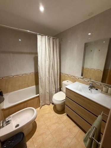 Un baño con lavabo, inodoro y bañera. en El Pasaje Apartamento, en Oviedo