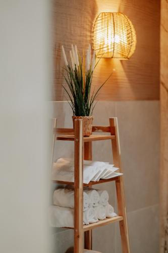 a bathroom with a shelf with towels and a potted plant at Parkhotel Papenburg by Hackmann in Papenburg