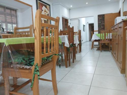 a dining room with wooden chairs and a table at Lily Guesthouse in Bloemfontein