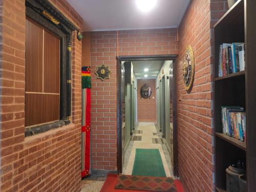 un corridoio con un muro di mattoni e un corridoio di mattoni rossi di Nepal Blissful Nest And Family Home a Kathmandu