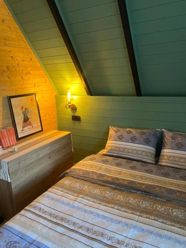a bedroom with a bed in a attic at Oda to Didvela -ოდა დიდველაში 